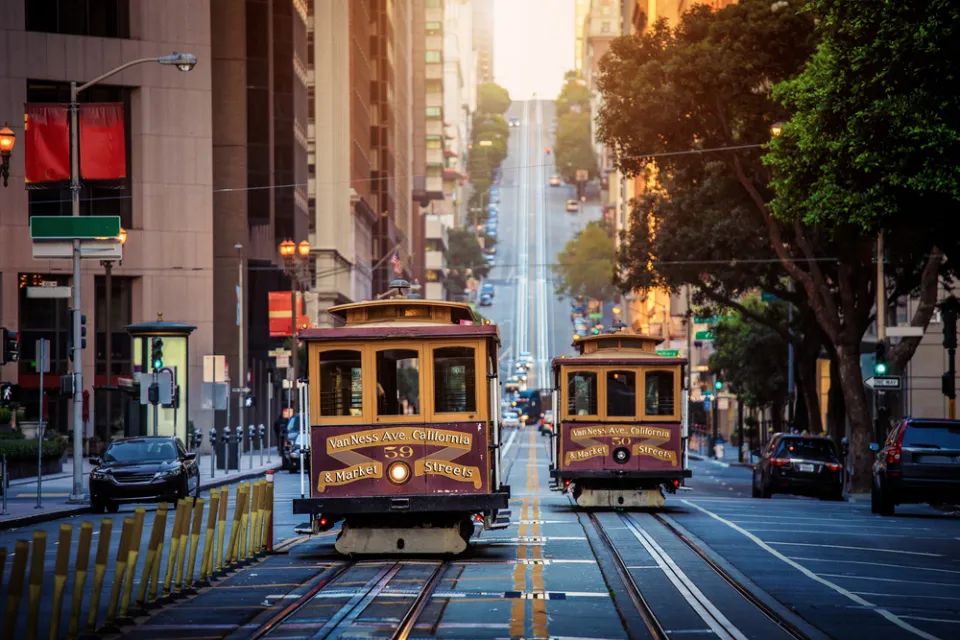 Historic cable cars on California Street in San Francisco, California with hill and city buildings in background